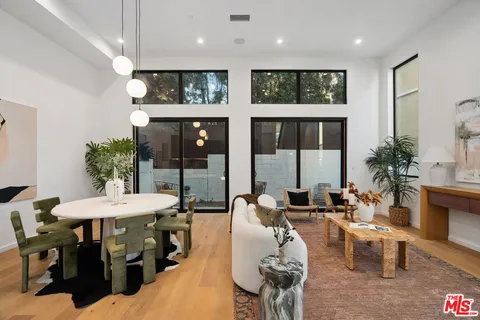 a living room with furniture a chandelier and a floor to ceiling window