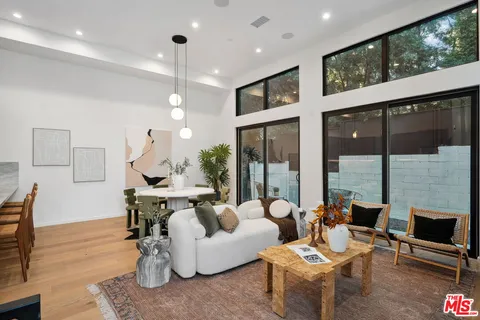 a living room with fireplace furniture and a large window