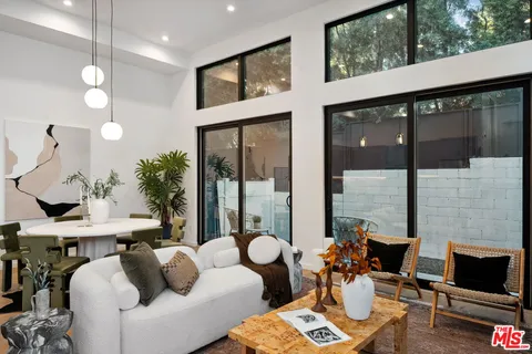a living room with furniture and a floor to ceiling window