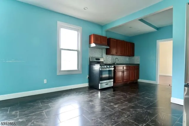 a kitchen with granite countertop a stove a sink and a microwave