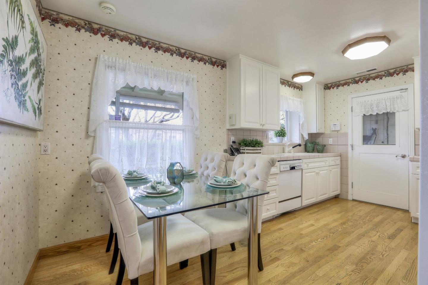 66 Church Street Mountain View, CA 94041 - Photo 12 of 45 a kitchen with stainless steel appliances a white table chairs and a refrigerator