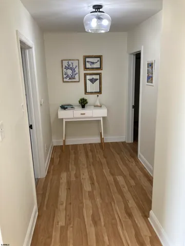 a view of a hallway with wooden floor and workspace