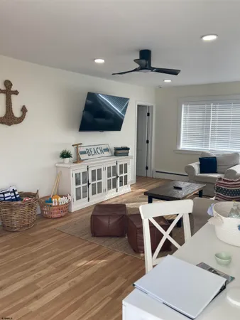 a living room with furniture a flat screen tv and kitchen view