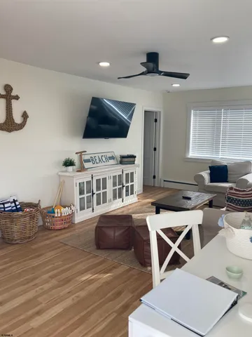 a living room with furniture a flat screen tv and kitchen view