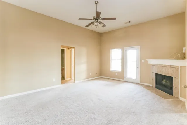 a view of an empty room with a fireplace and a window