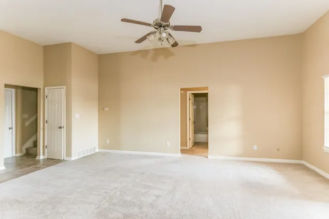 a view of an empty room with a ceiling fan