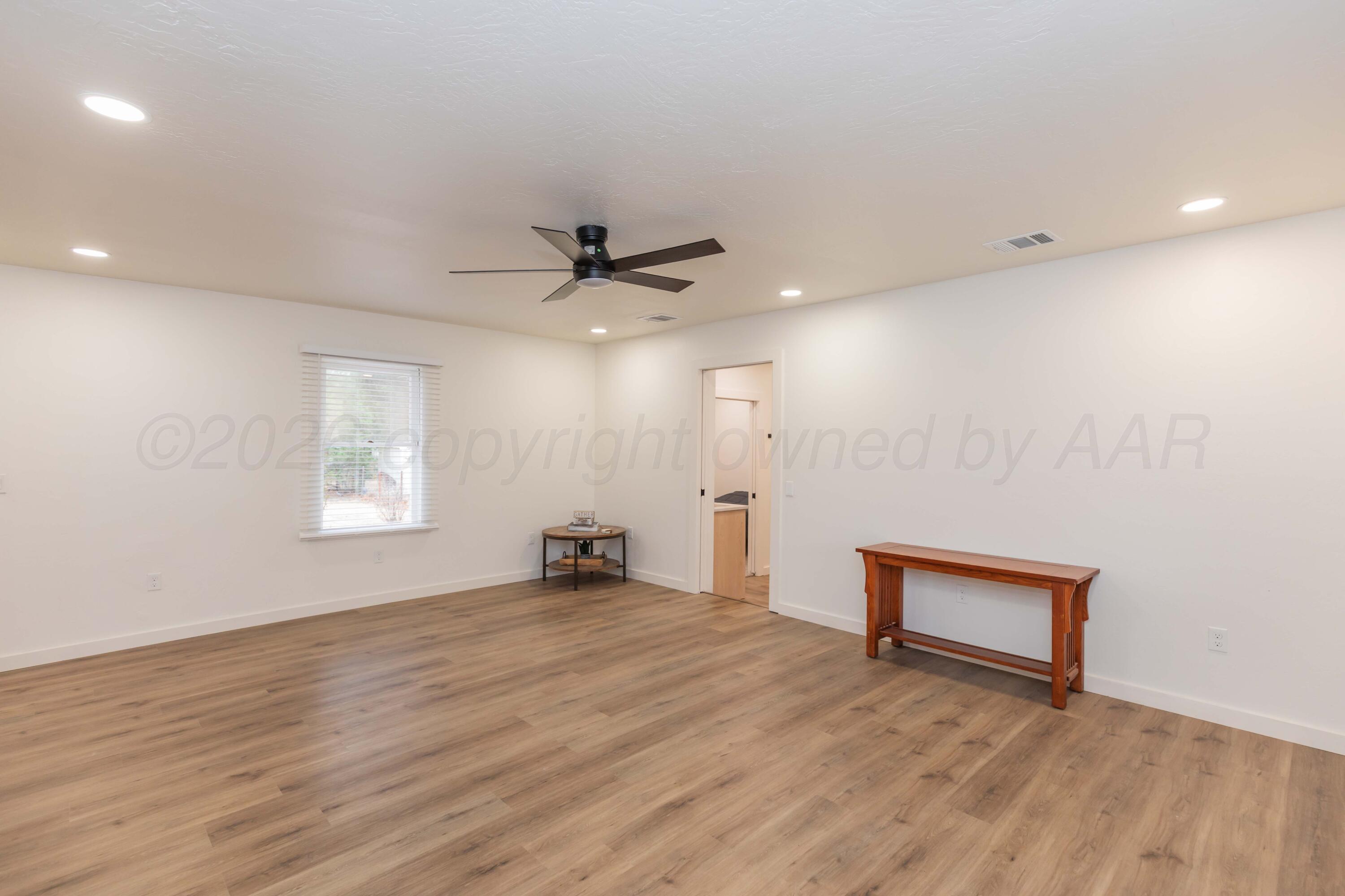 504 High Street Claude, TX 79019 - Photo 24 of 39 an empty room with wooden floor and windows