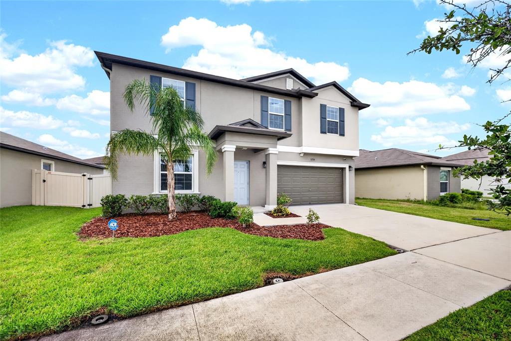 31724 Sun Kettle Loop Wesley Chapel, FL 33545 - Photo 45 of 49 a front view of a house with a garden and plants