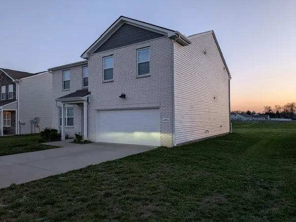 a view of a house with backyard and garden