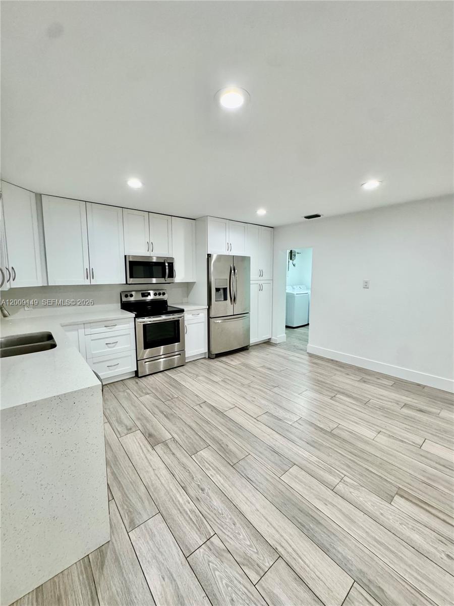 11770 Southwest 178th Terrace Miami, FL 33177 - Photo 4 of 13 a large kitchen with stainless steel appliances a large counter top a stove and a refrigerator