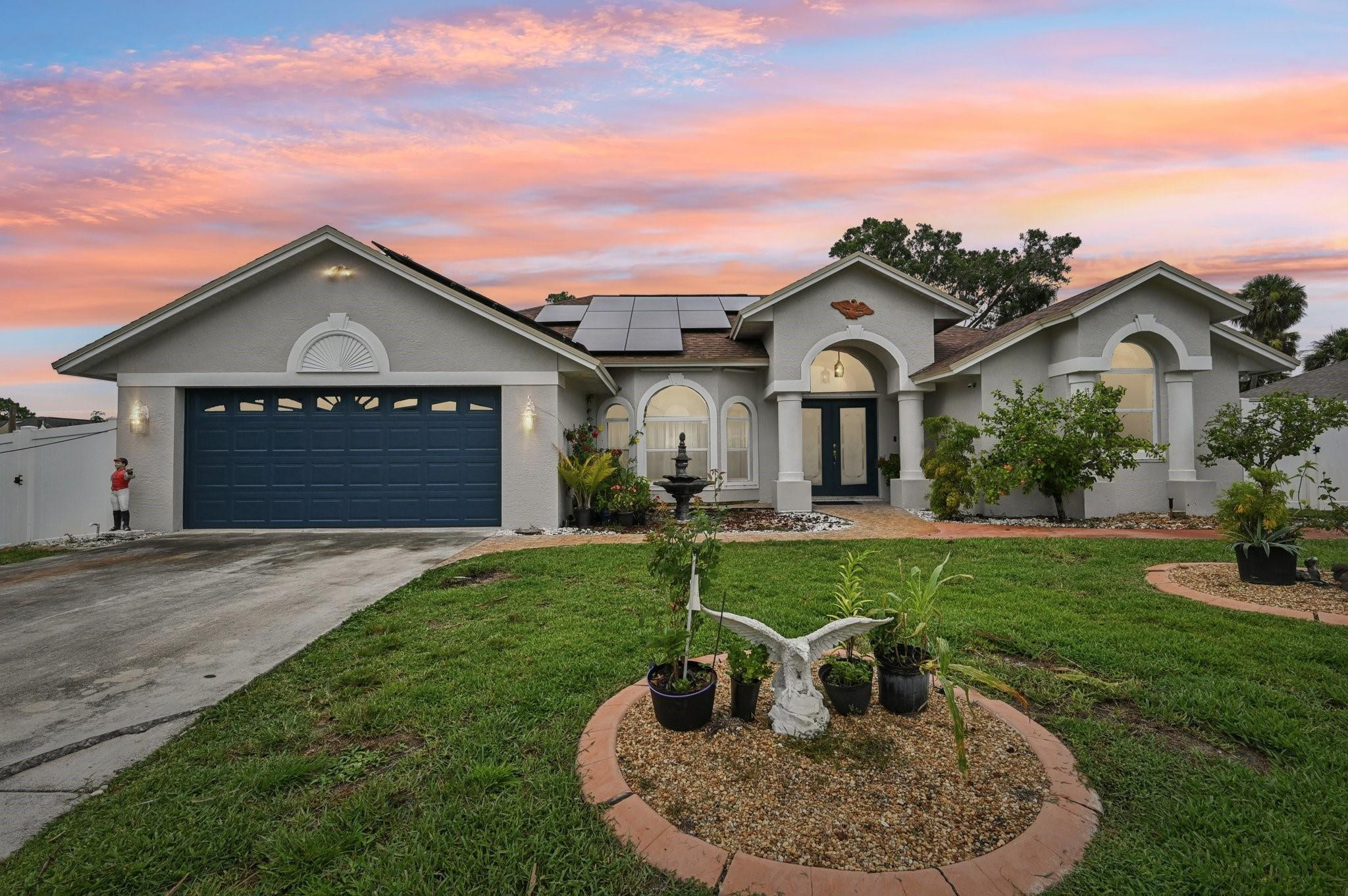 2041 Southwest Villanova Road Port St. Lucie, FL 34953 - Photo 1 of 45 a front view of a house with a garden and yard