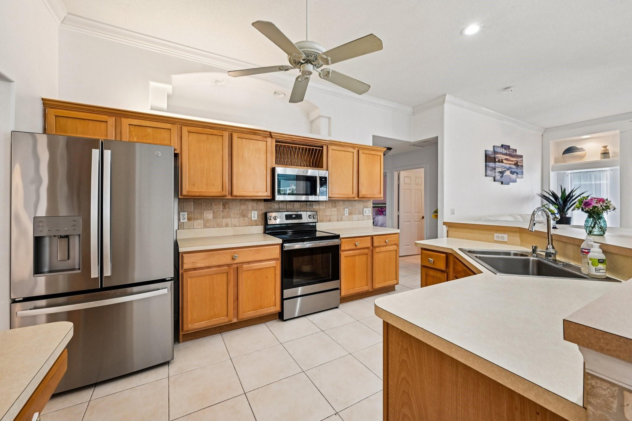 2041 Southwest Villanova Road Port St. Lucie, FL 34953 - Photo 14 of 45 a kitchen with granite countertop a refrigerator a sink a stove top oven a washer dryer and cabinets