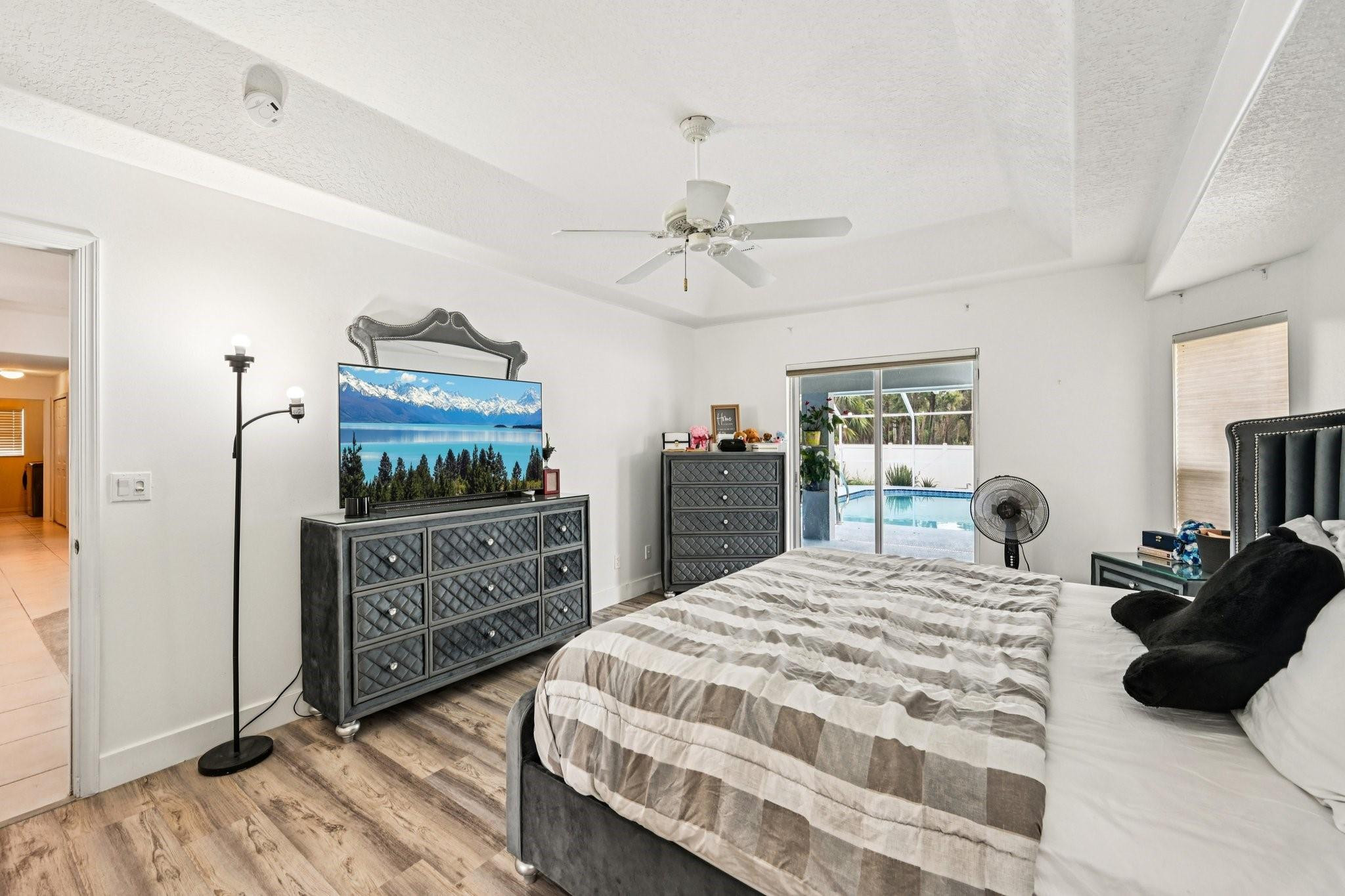 2041 Southwest Villanova Road Port St. Lucie, FL 34953 - Photo 19 of 45 a bedroom with a bed a dresser and potted plants