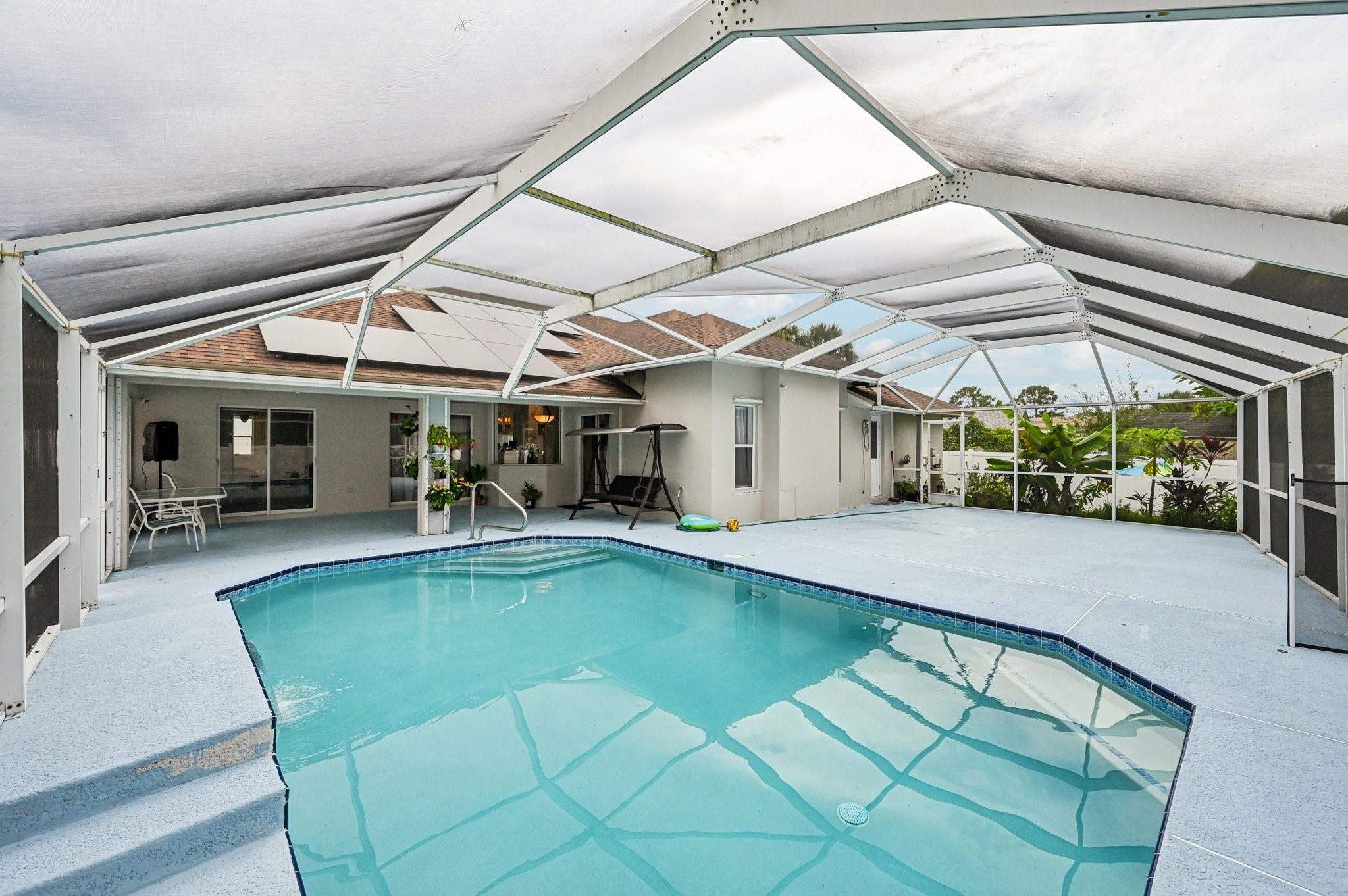 2041 Southwest Villanova Road Port St. Lucie, FL 34953 - Photo 32 of 45 a view of a patio with a table and chairs under an umbrella