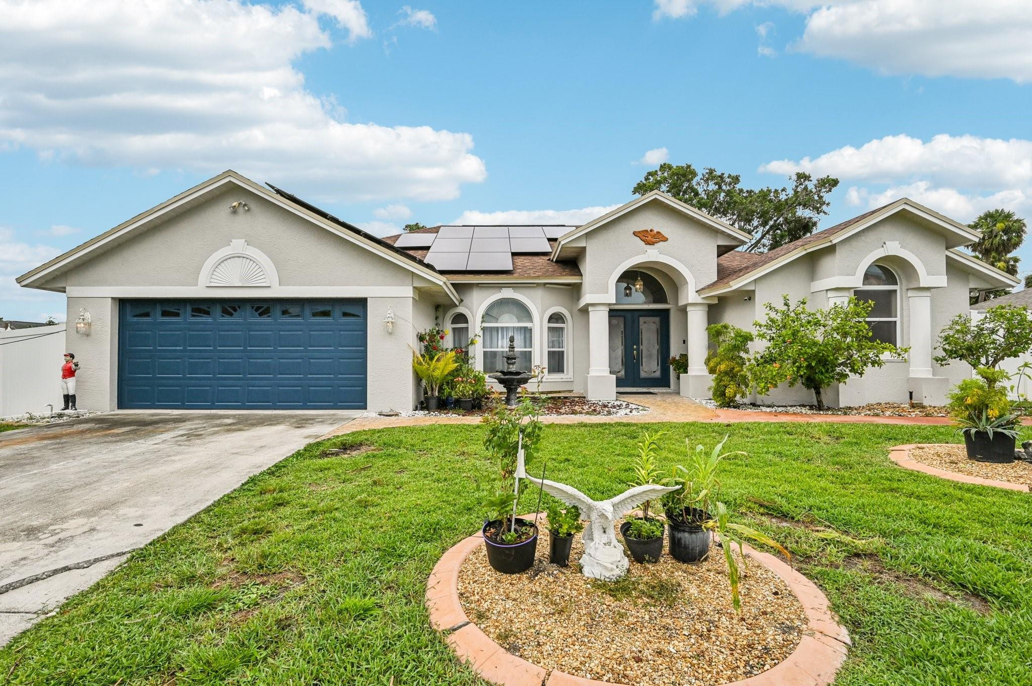 2041 Southwest Villanova Road Port St. Lucie, FL 34953 - Photo 4 of 45 a front view of a house with a yard and garage