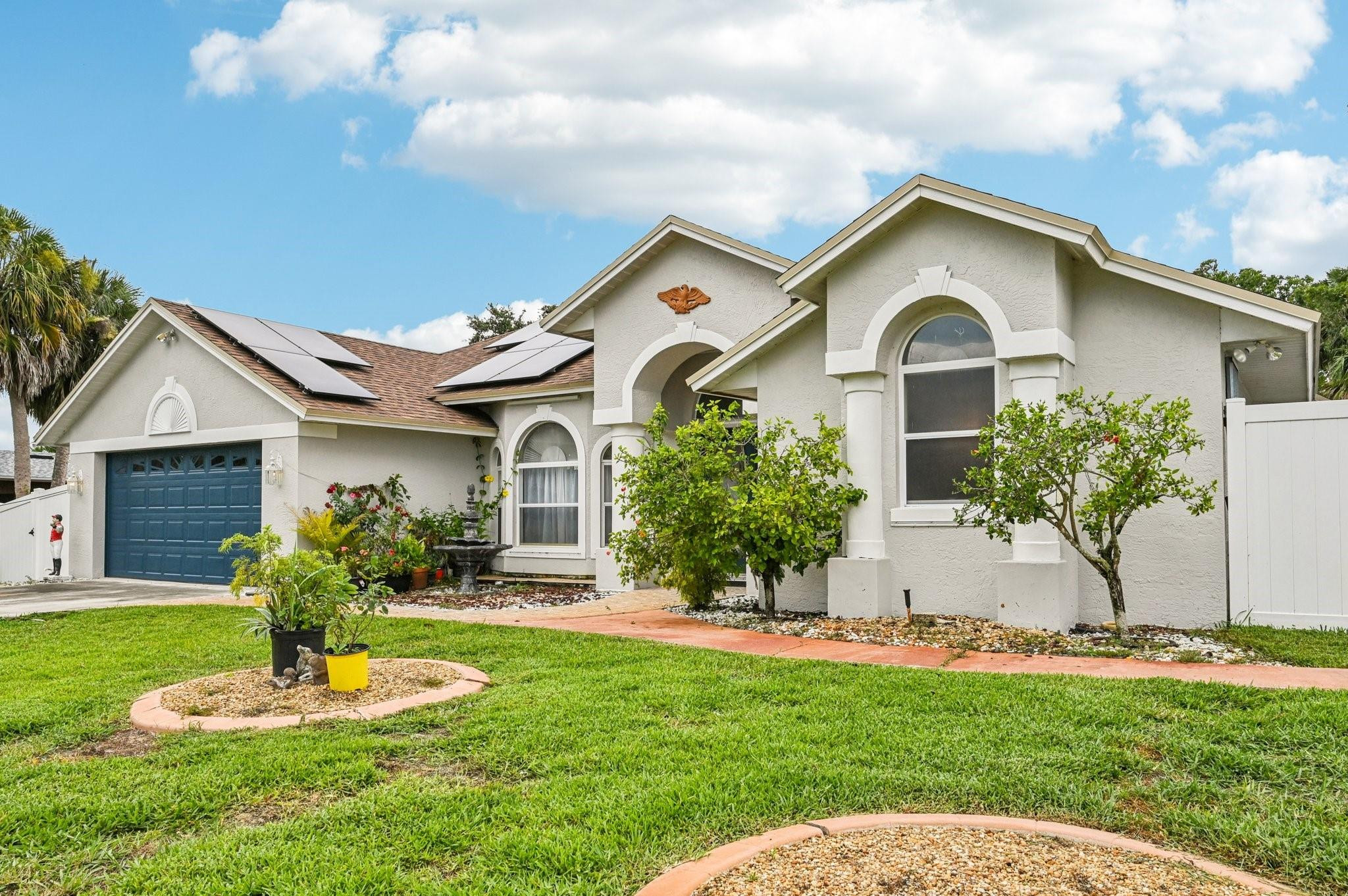 2041 Southwest Villanova Road Port St. Lucie, FL 34953 - Photo 5 of 45 a front view of a house with a yard and garage