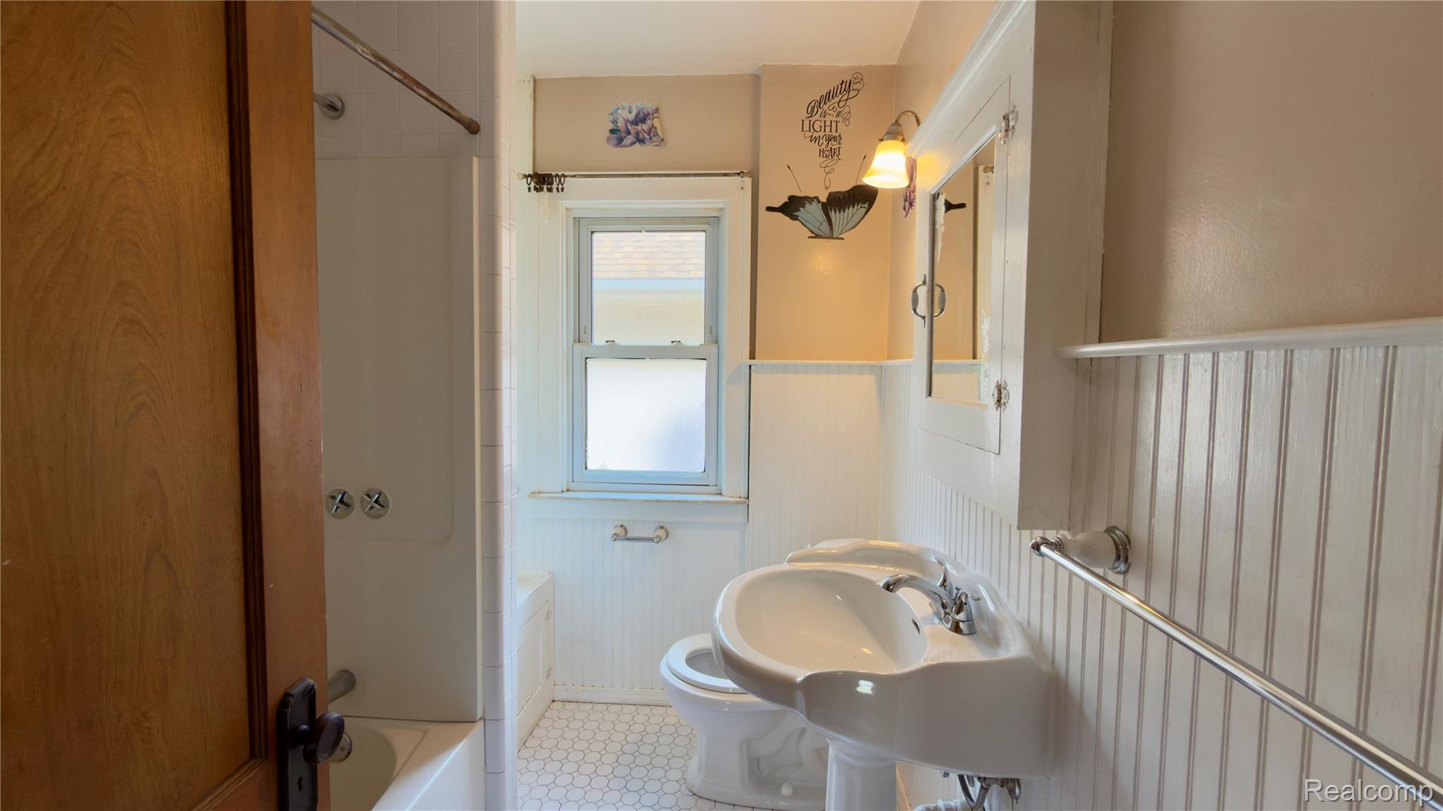 130 Elm Street River Rouge, MI 48218 - Photo 20 of 20 Bathroom featuring a white pedestal sink, hex tile flooring, beadboard wainscoting, and a window with privacy film
