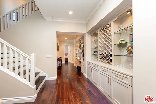 a hallway with white cabinets and wooden floor
