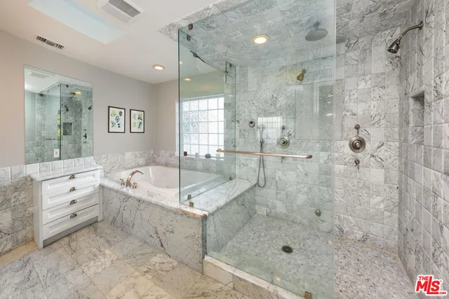 a bathroom with a granite countertop bathtub shower sink and mirror