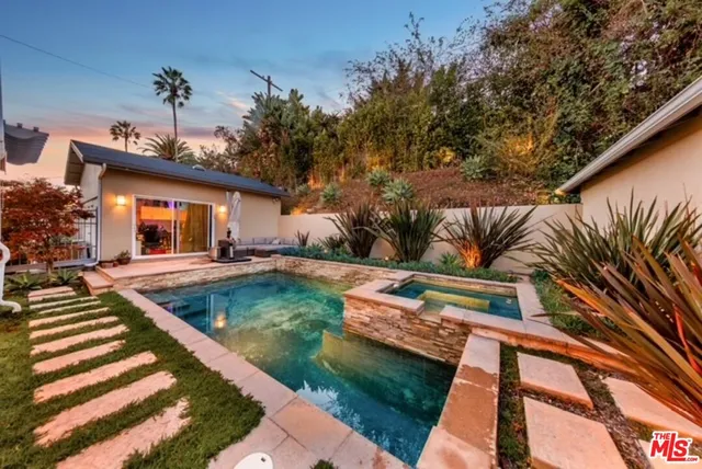 a view of a house with backyard and sitting area