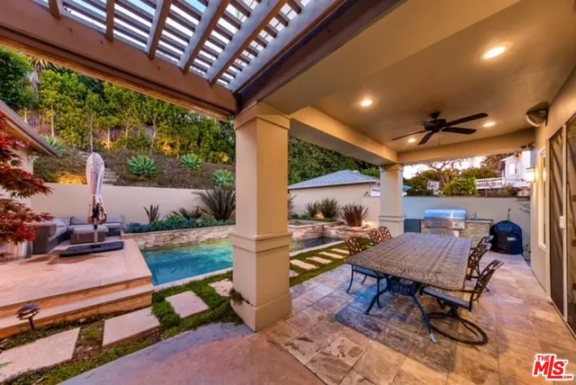 a view of a patio with table and chairs and potted plants with wooden floor