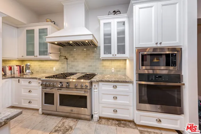 a kitchen with stainless steel appliances granite countertop a stove and a microwave