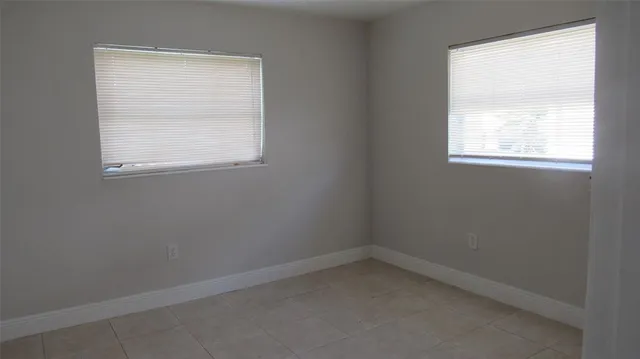 an empty room with closet and windows