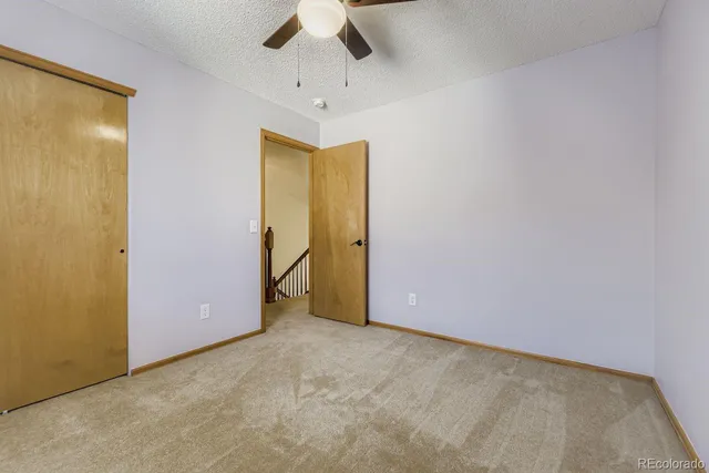 an empty room with a ceiling fan and a window