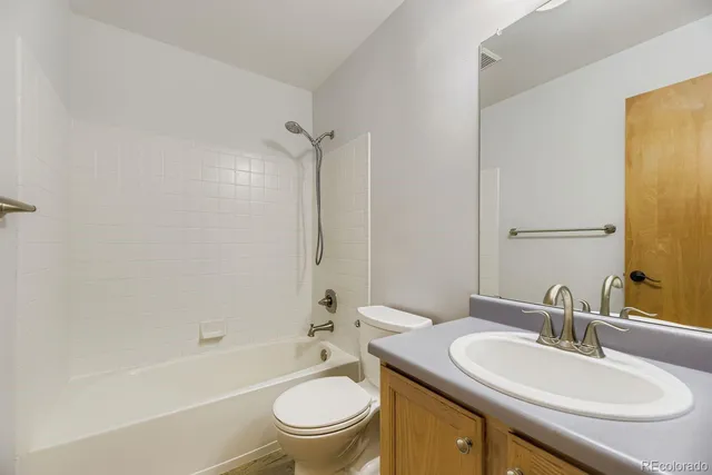 a bathroom with a sink toilet tub vanity and shower