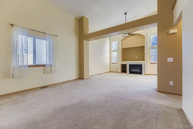 an empty room with a fireplace and a window