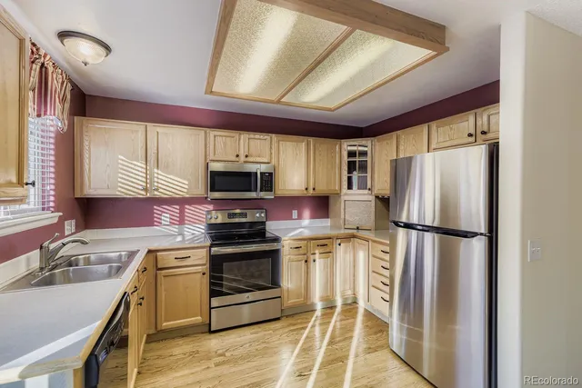 a kitchen with stainless steel appliances a refrigerator sink and microwave