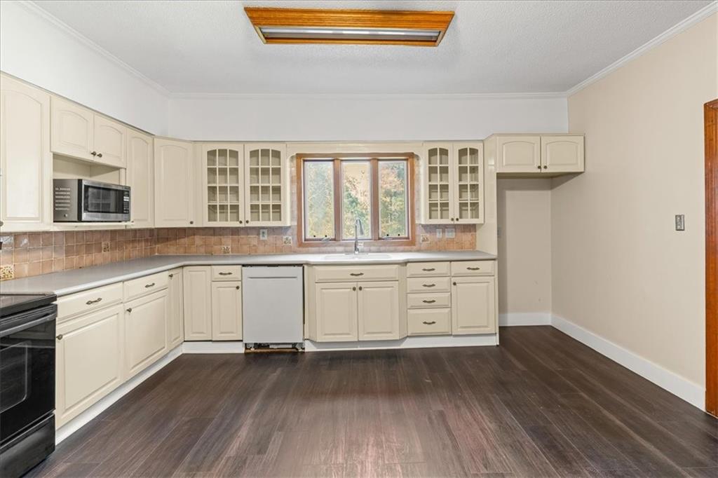 110 A Williams Road Southeast Silver Creek, GA 30173 - Photo 25 of 61 a kitchen with stainless steel appliances a stove and white cabinets with wooden floor