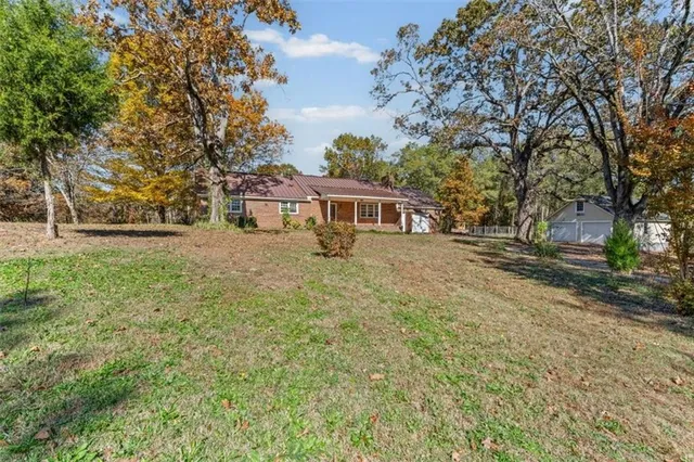 a view of an house with backyard and trees