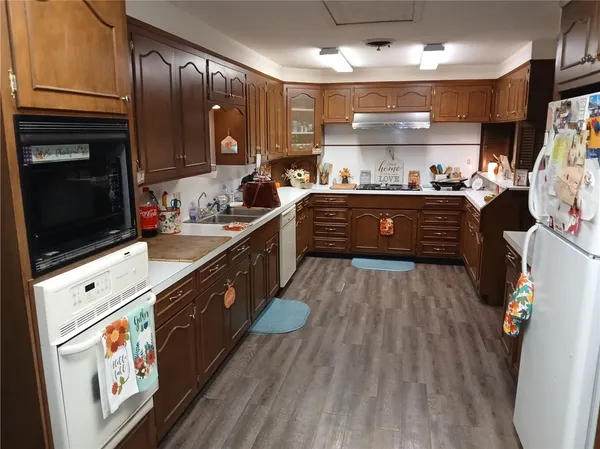 a large kitchen with stainless steel appliances kitchen island granite countertop a large stove a sink dishwasher and cabinets with wooden floor