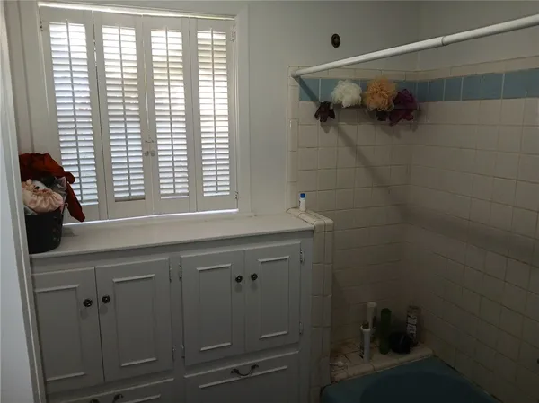 a bathroom with a bathtub a shower and a window