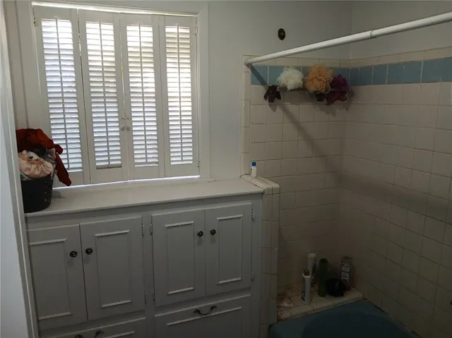 a bathroom with a bathtub a shower and a window