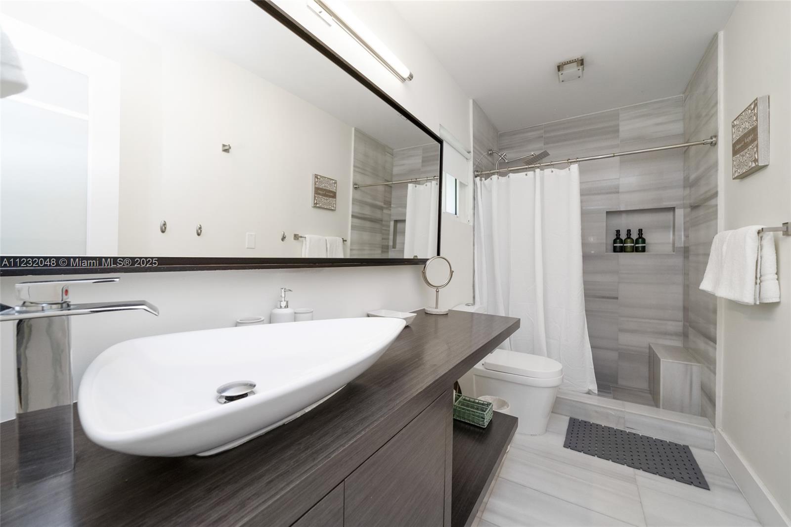 7544 Southwest 78th Terrace Miami, FL 33143 - Photo 30 of 60 a bathroom with a sink a mirror and a bathtub