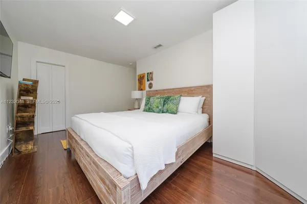 a bedroom with a bed and a painting on the wall