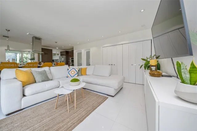 a dining room filled with furniture and a potted plant