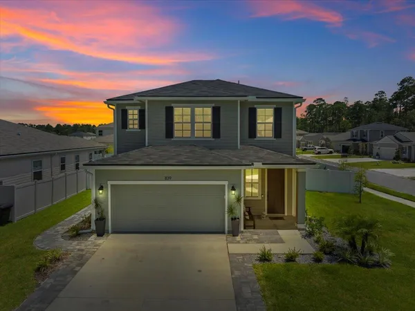 a front view of a house with a garden and yard