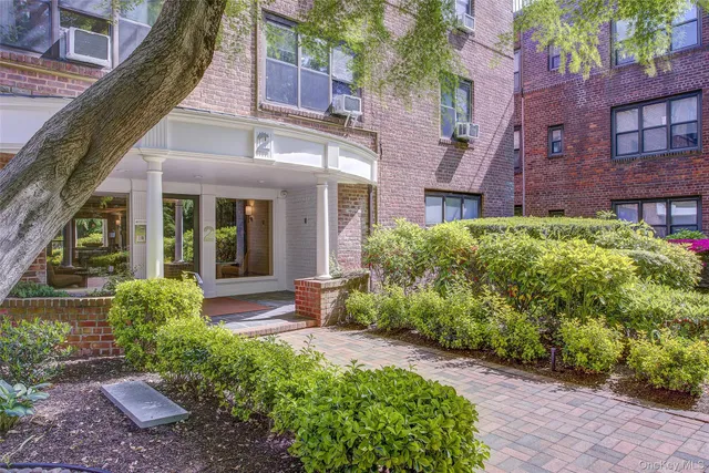 front view of a brick house with a yard
