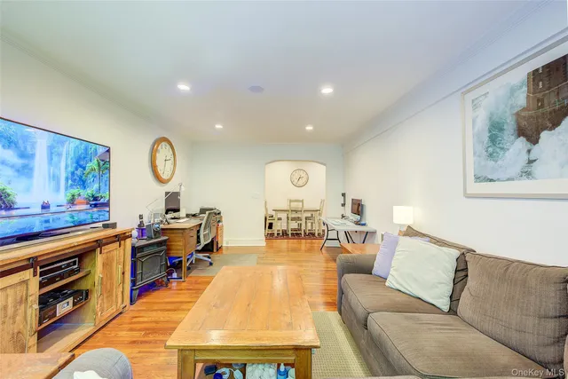 a living room with furniture a flat screen tv and kitchen view