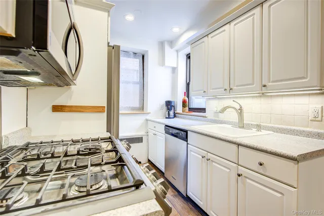 a kitchen with stainless steel appliances granite countertop a sink stove and cabinets