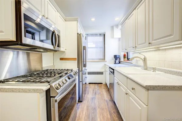 a kitchen with stainless steel appliances granite countertop a sink stove and cabinets