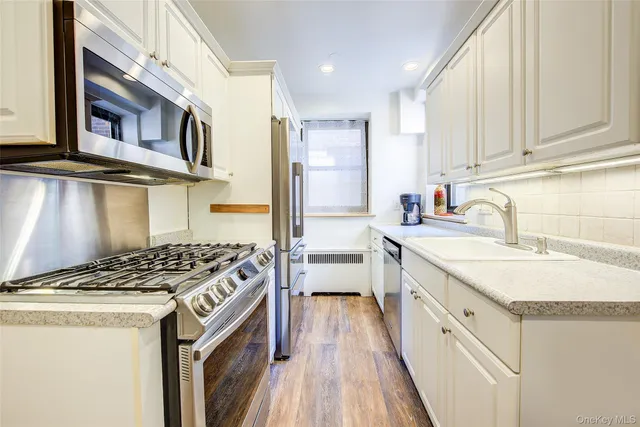a kitchen with stainless steel appliances granite countertop a sink stove and cabinets