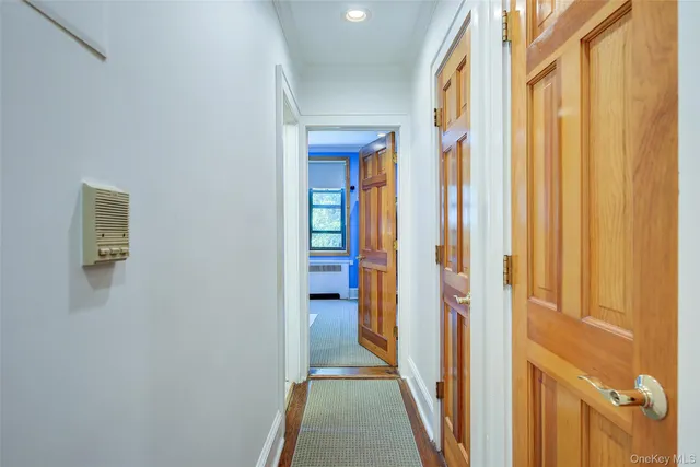a view of a hallway with wooden floor and staircase