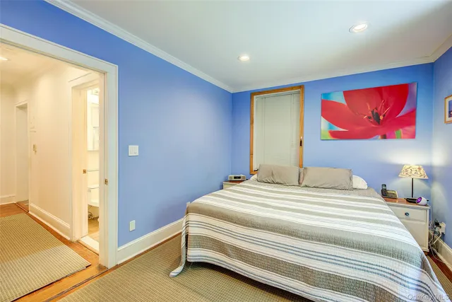 a bedroom with bed and wall painting with wooden floor