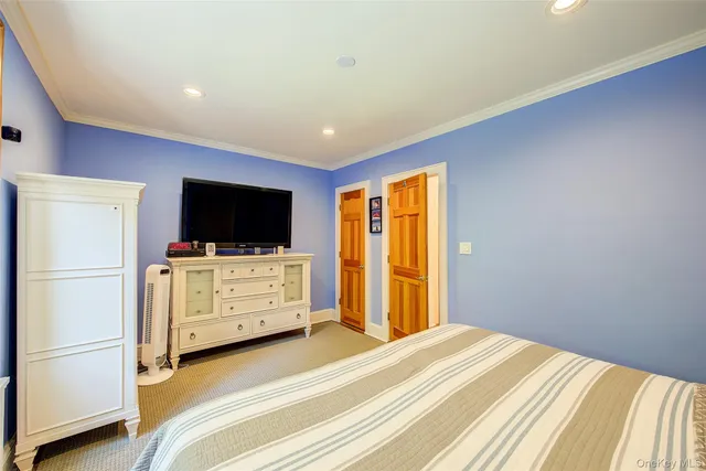 a bedroom with a bed and flat screen tv