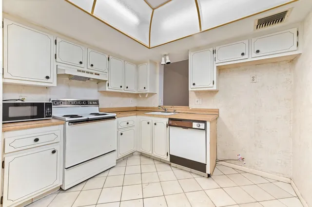 a kitchen with cabinets and white appliances