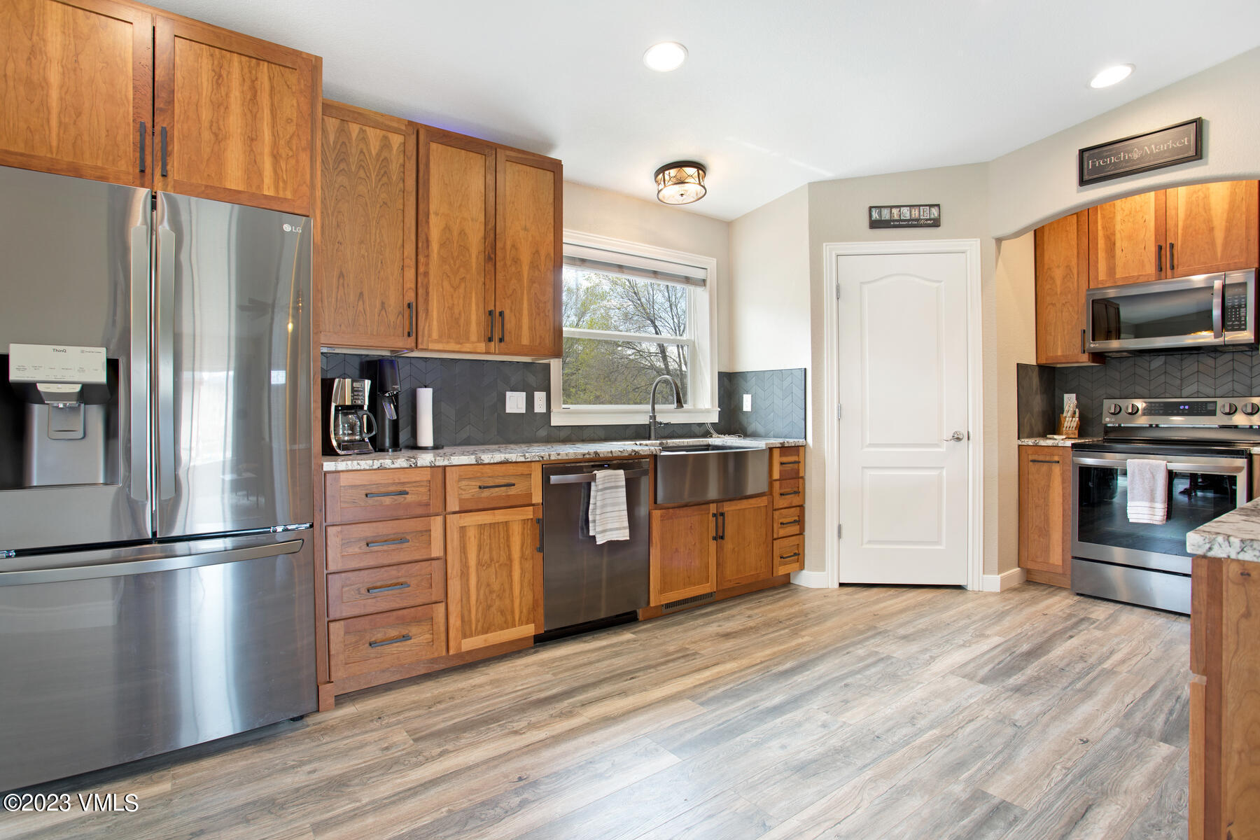 376 Blacksmith Road Eagle, CO 81631 - Photo 9 of 32 a kitchen with stainless steel appliances granite countertop a refrigerator a sink dishwasher a stove with wooden cabinets and wooden floor
